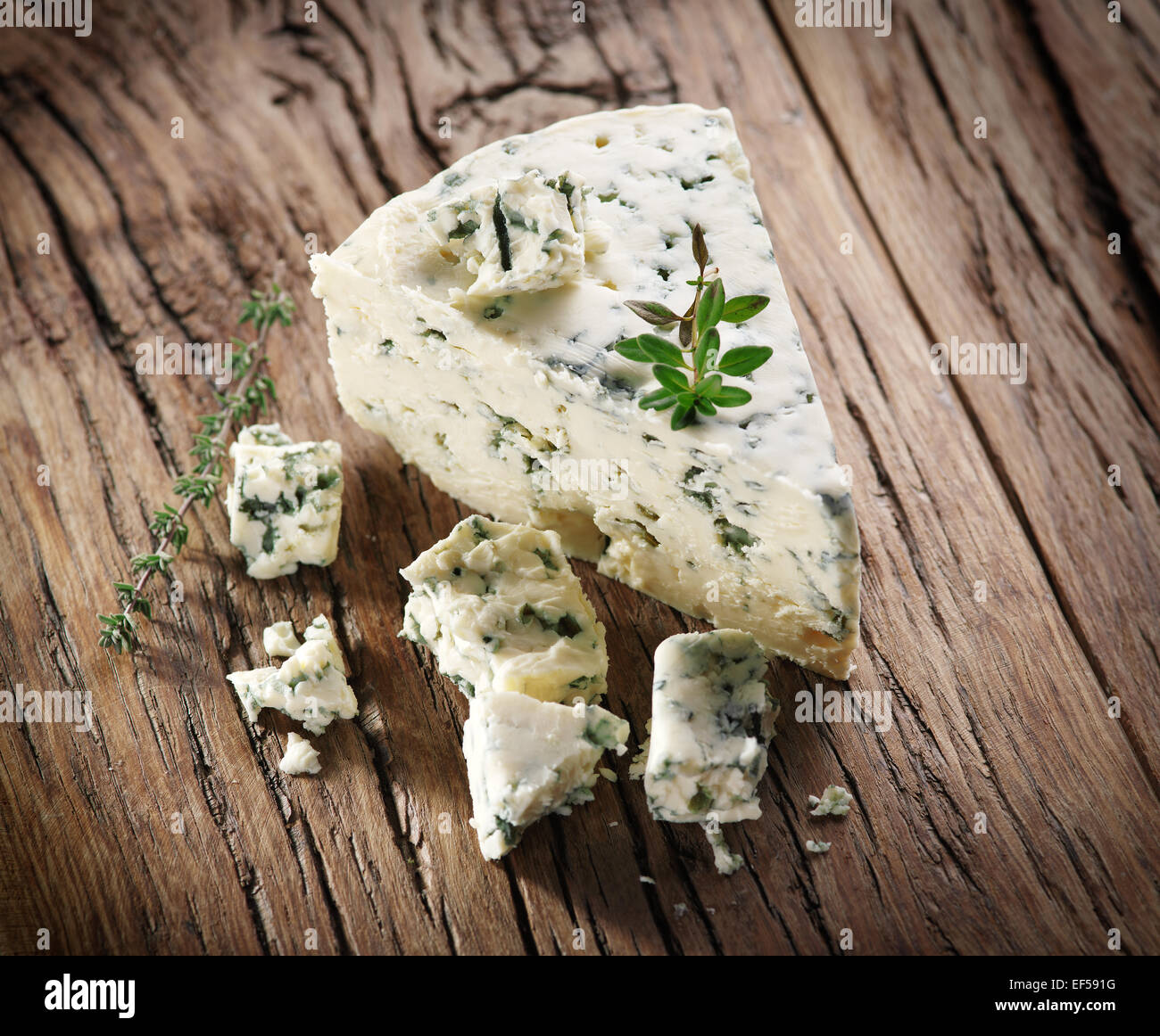 Slices of Danish Blue cheese on an old wooden table. Stock Photo