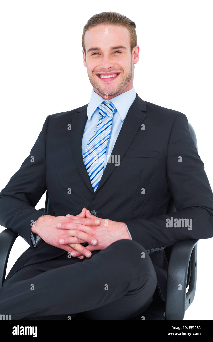 Smiling businessman sitting on an office chair Stock Photo - Alamy