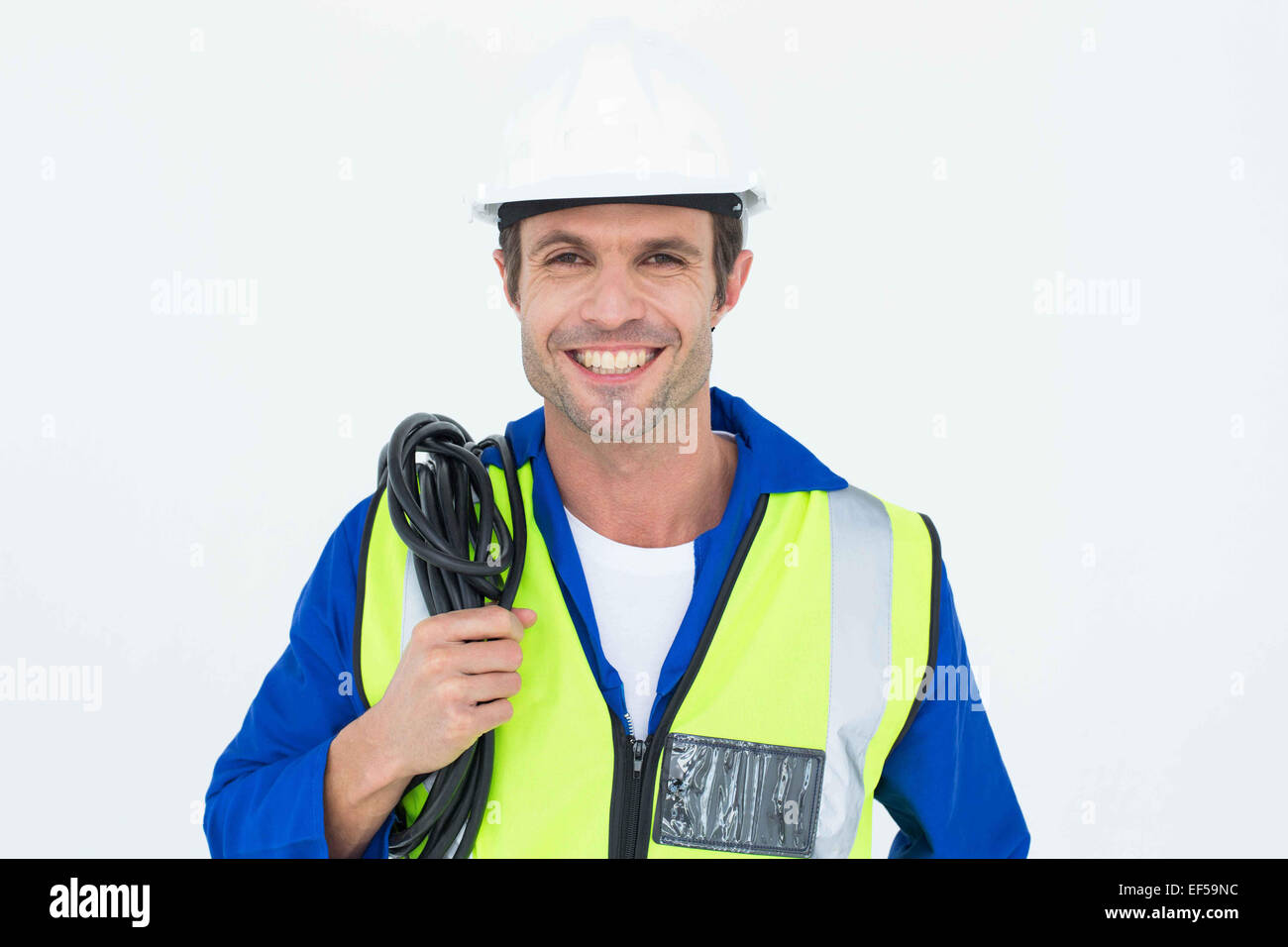 Confident electrician with wire against white background Stock Photo