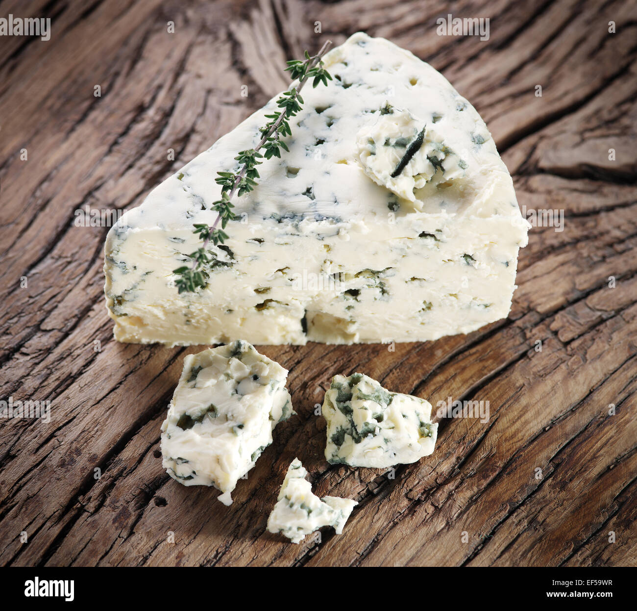 Slices of Danish Blue cheese on an old wooden table. Stock Photo