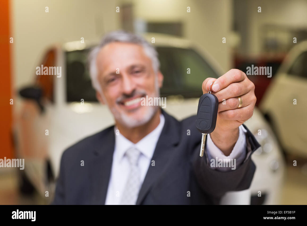 Smiling salesman giving a customer car keys Stock Photo - Alamy