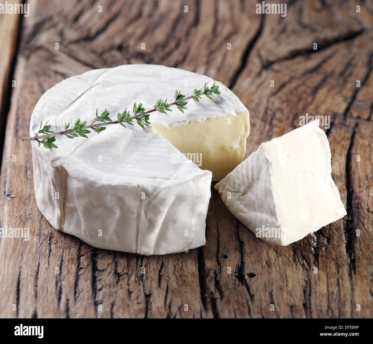 Camembert cheese on old wooden table. Stock Photo