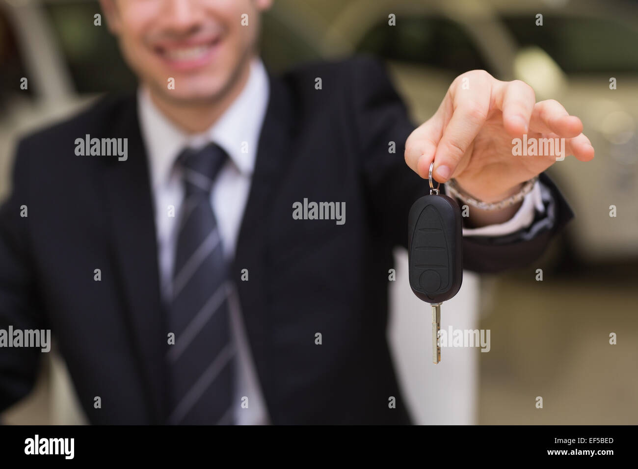 Smiling salesman giving a customer car keys Stock Photo - Alamy