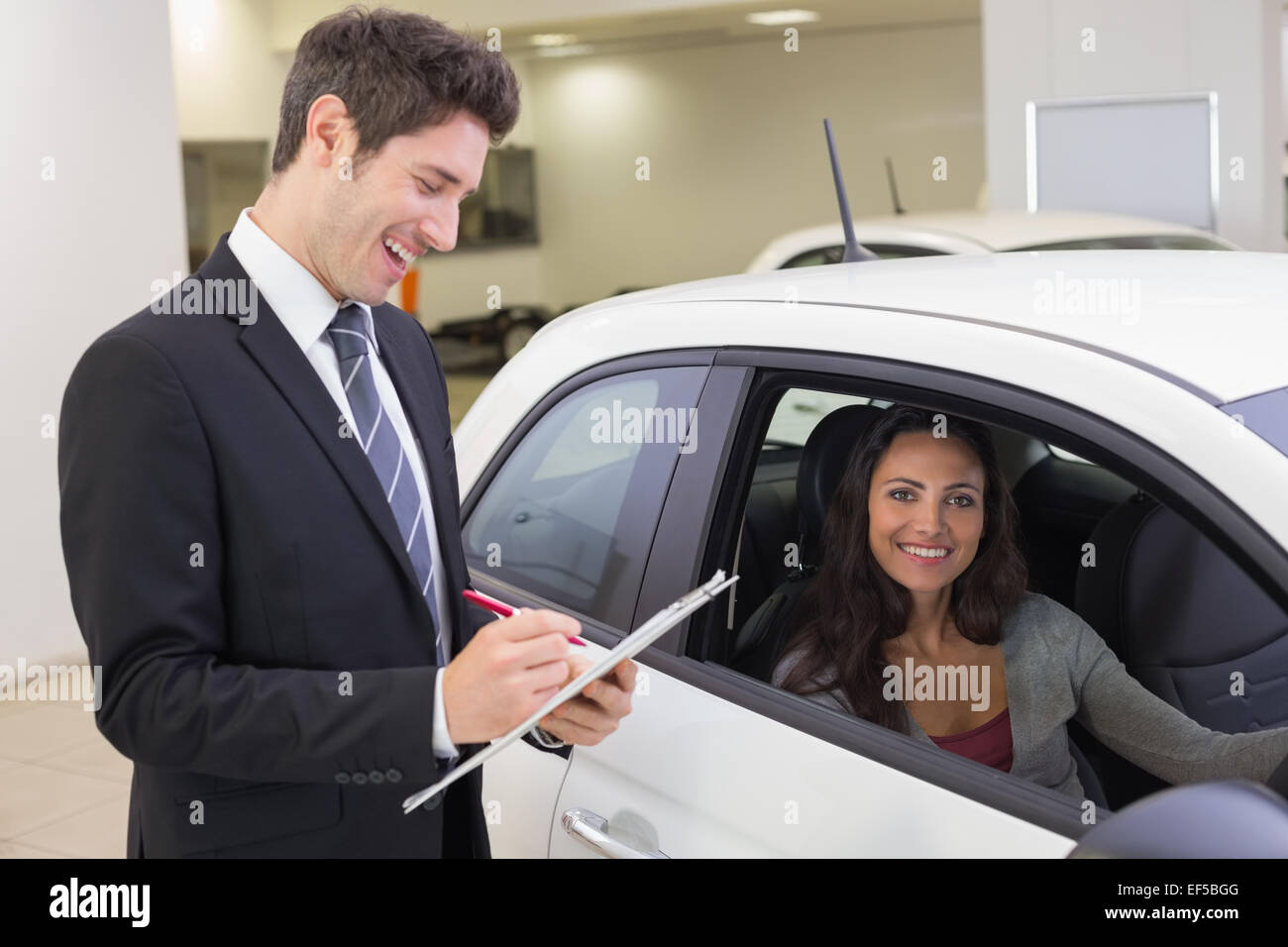 Smiling businessman writing on clipboard Stock Photo - Alamy