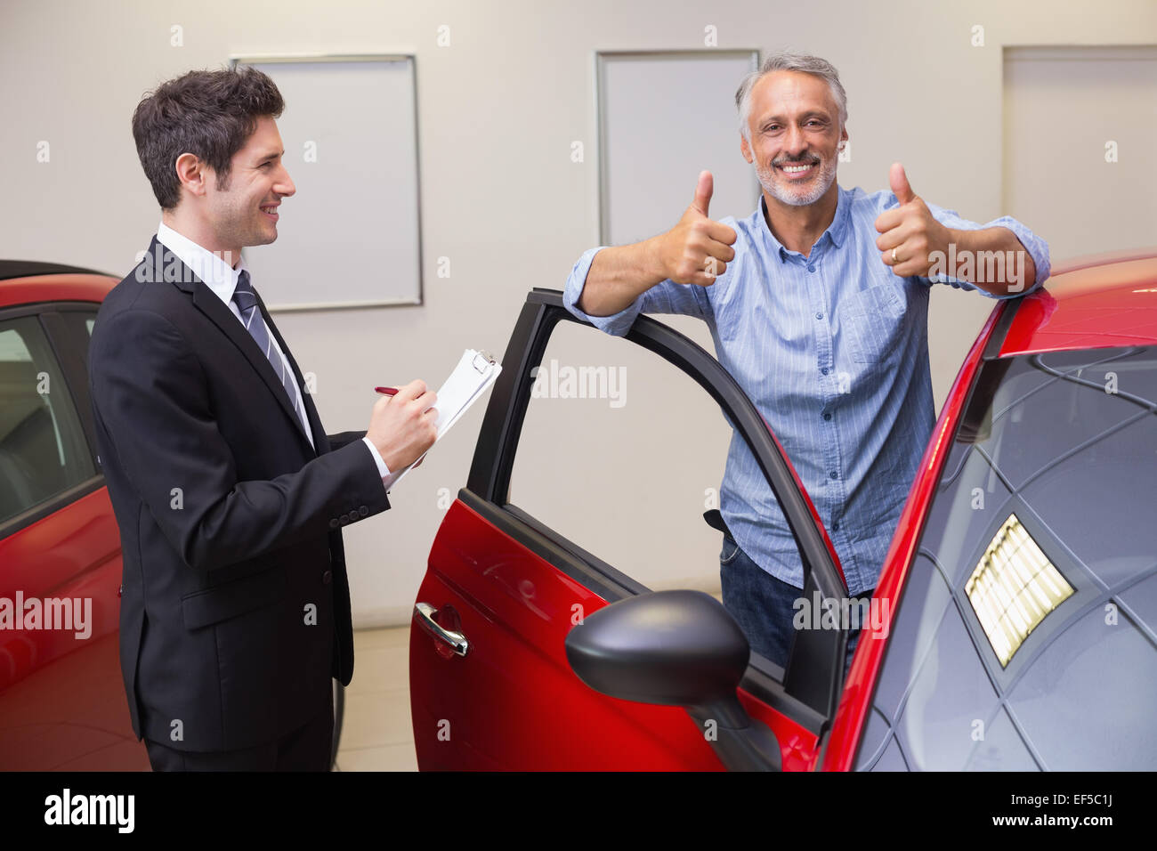 Smiling customer giving thumbs up Stock Photo - Alamy