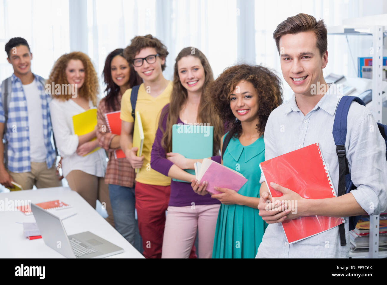 Students smiling at camera standing in a line Stock Photo - Alamy