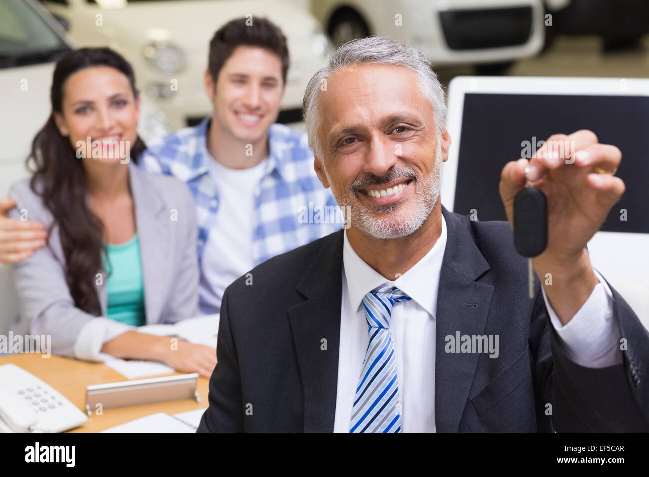 Smiling businessman showing a car key Stock Photo - Alamy