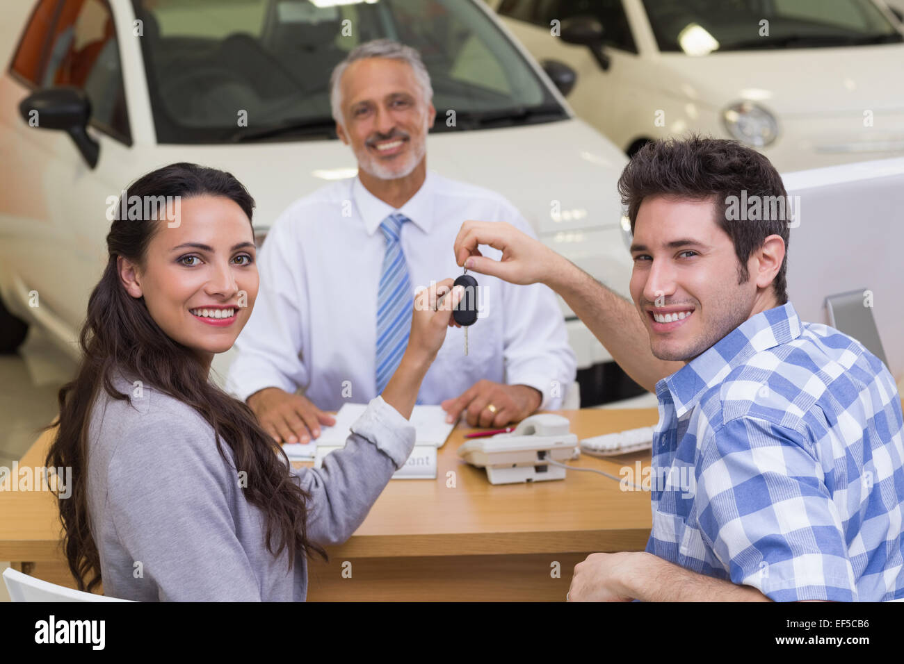 Smiling couple holding their new car key Stock Photo - Alamy