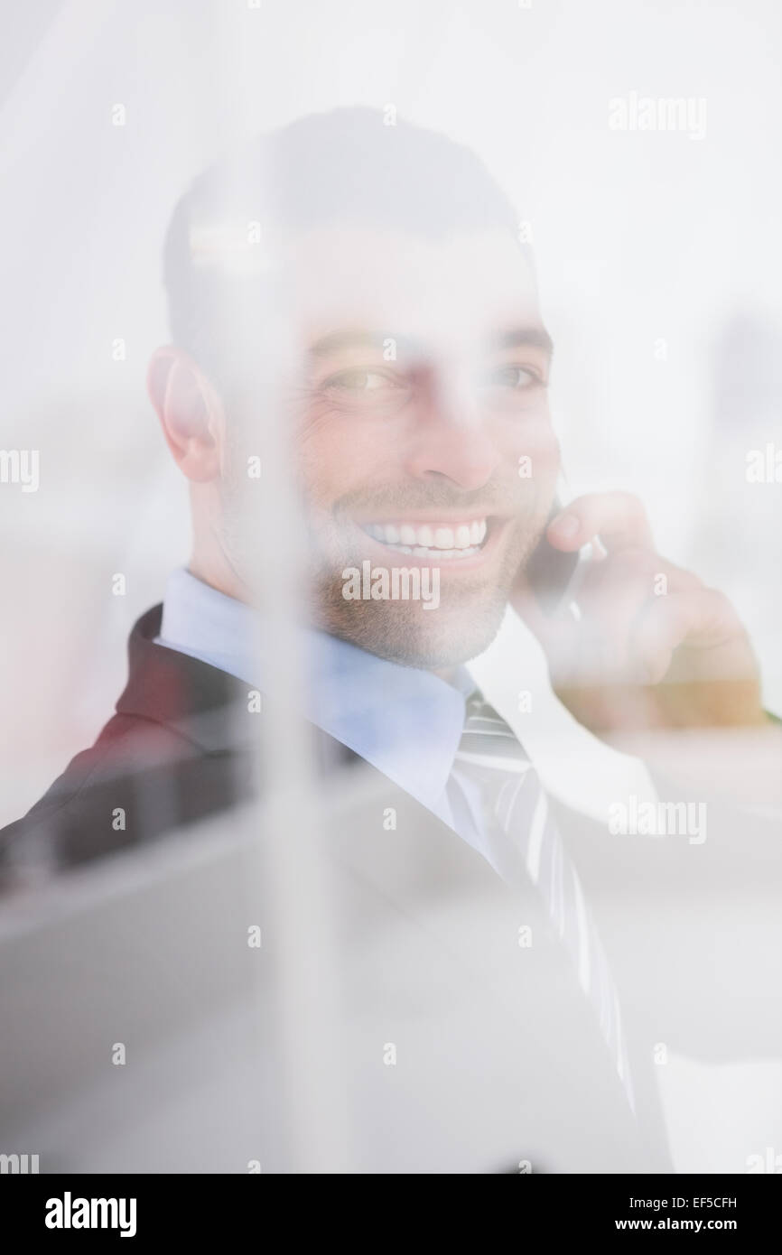 Smiling businessman looking at camera on the phone Stock Photo - Alamy