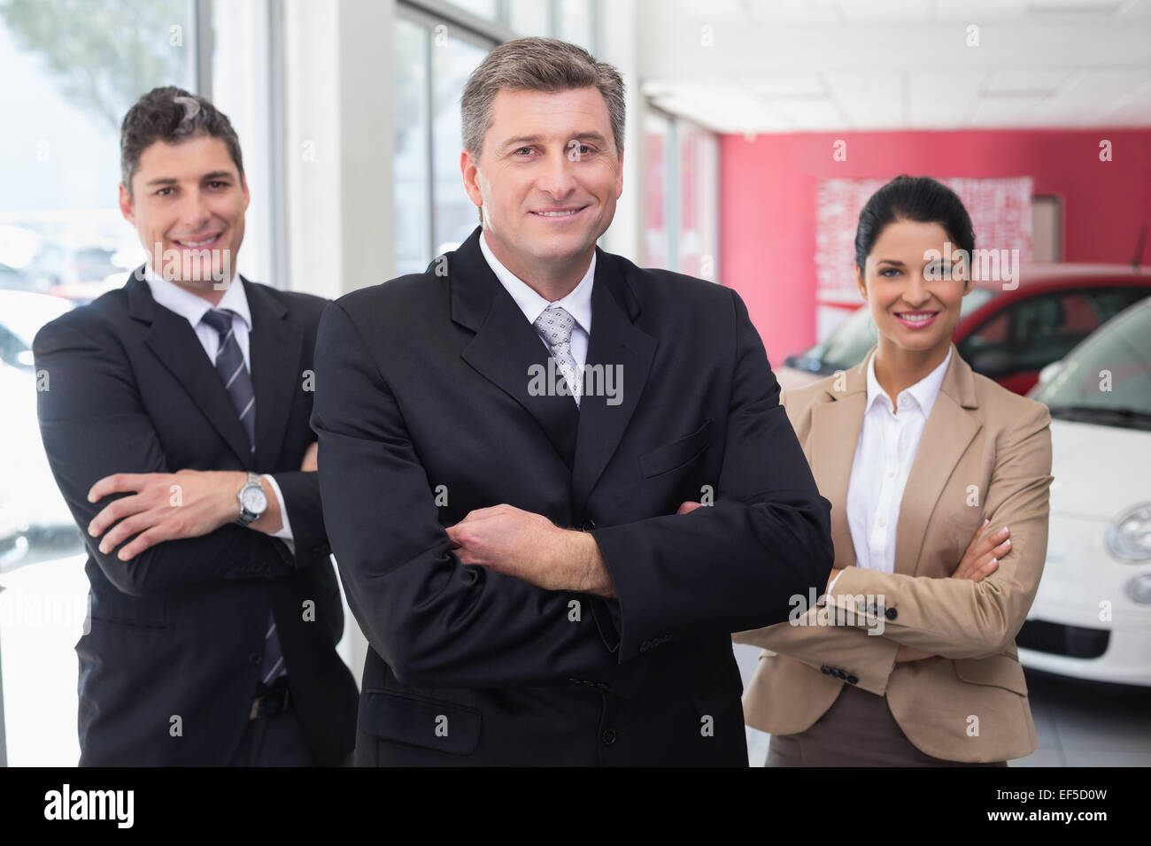 Smiling business team standing with arms crossed Stock Photo - Alamy
