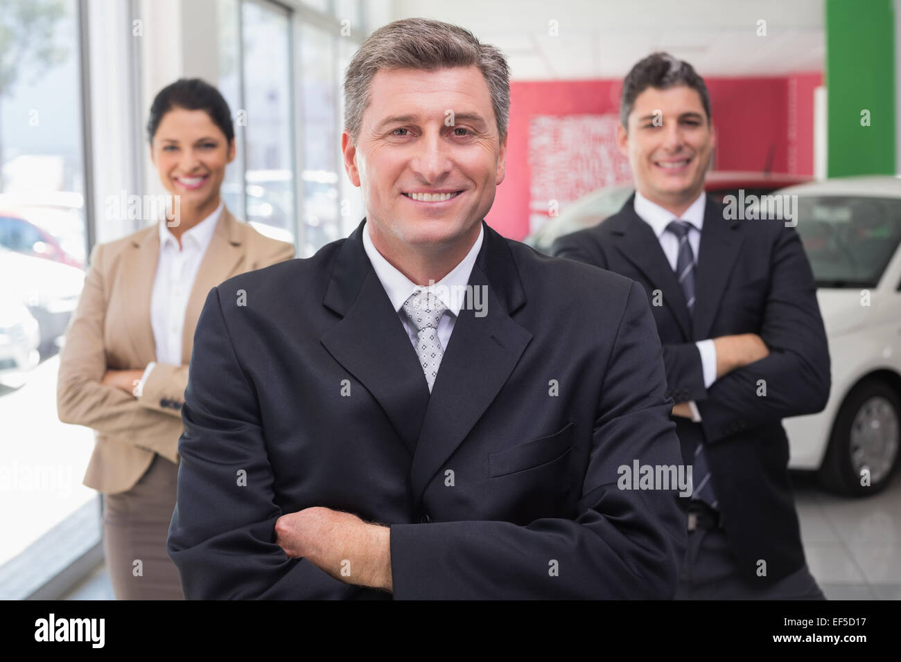 Smiling business team standing with arms crossed Stock Photo - Alamy
