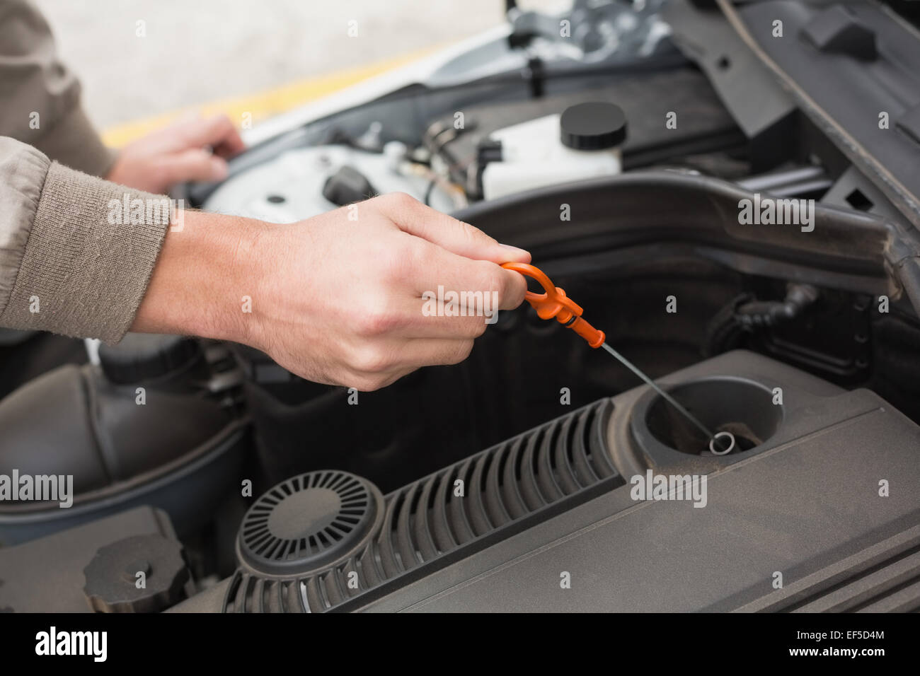 Man using dipstick to check oil Stock Photo Alamy