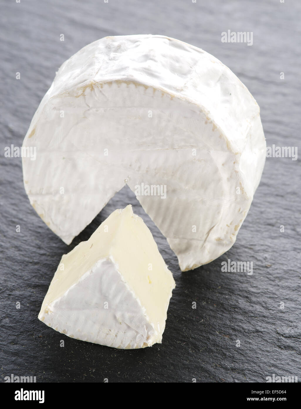 Camembert cheese on the gray stone surface. Stock Photo