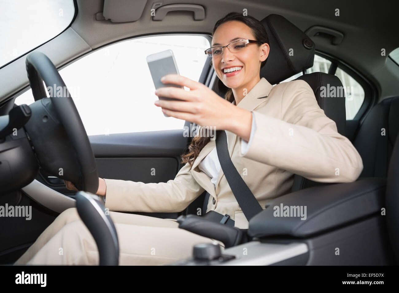 Smiling businesswoman sending a text message Stock Photo