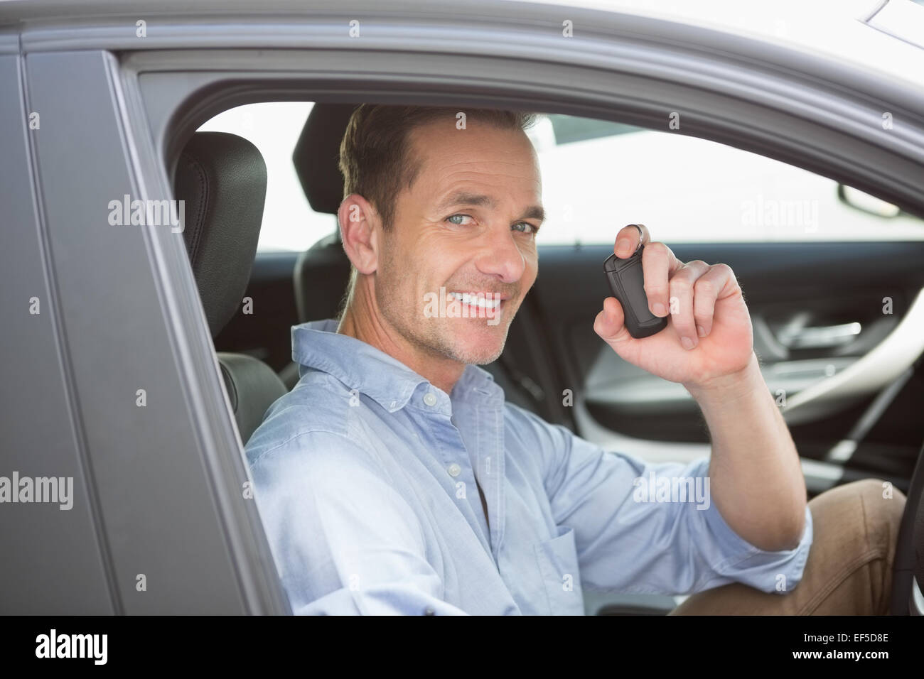 Handsome man smiling and holding key Stock Photo - Alamy