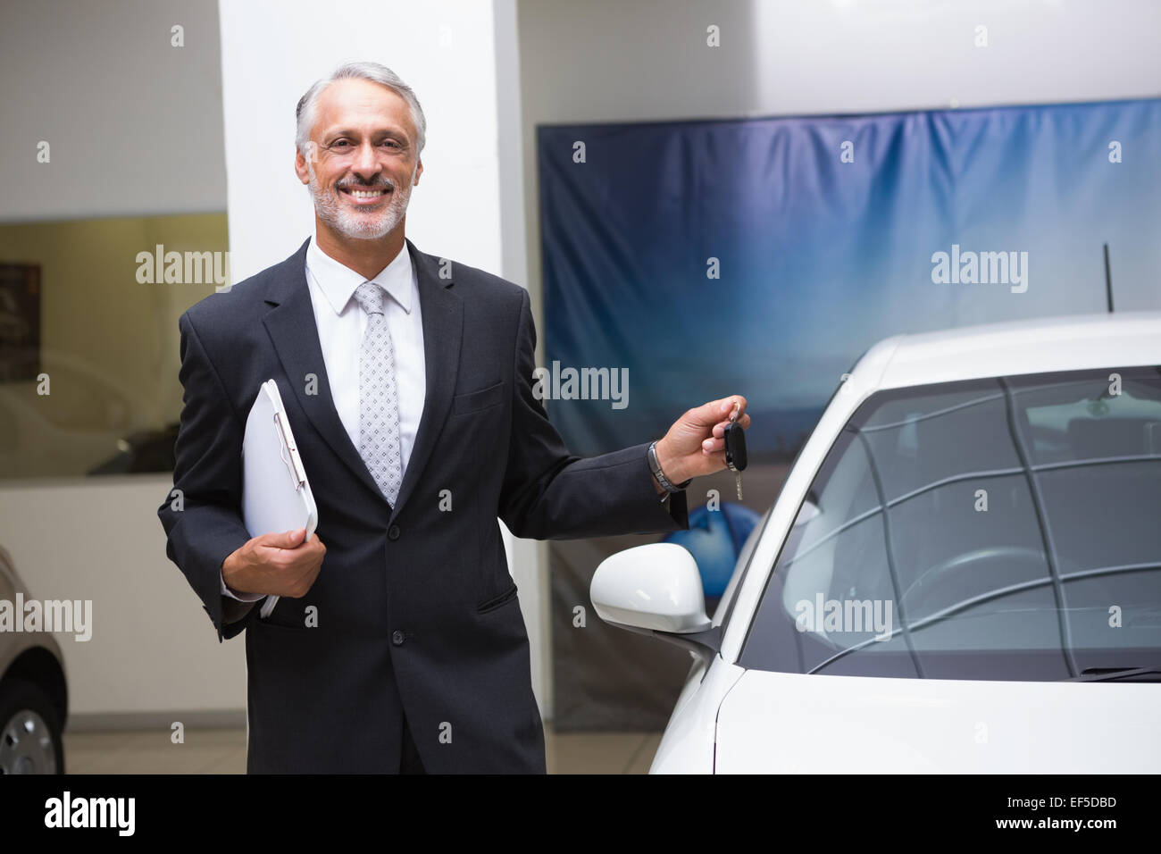 Smiling businessman holding car key and folder Stock Photo - Alamy