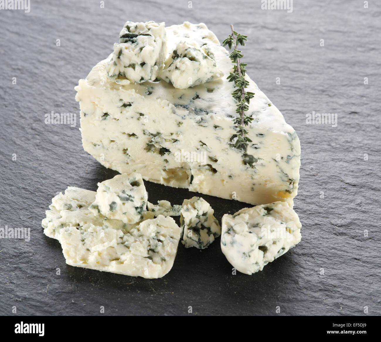 Slices of Danish Blue cheese on the gray stone surface. Stock Photo