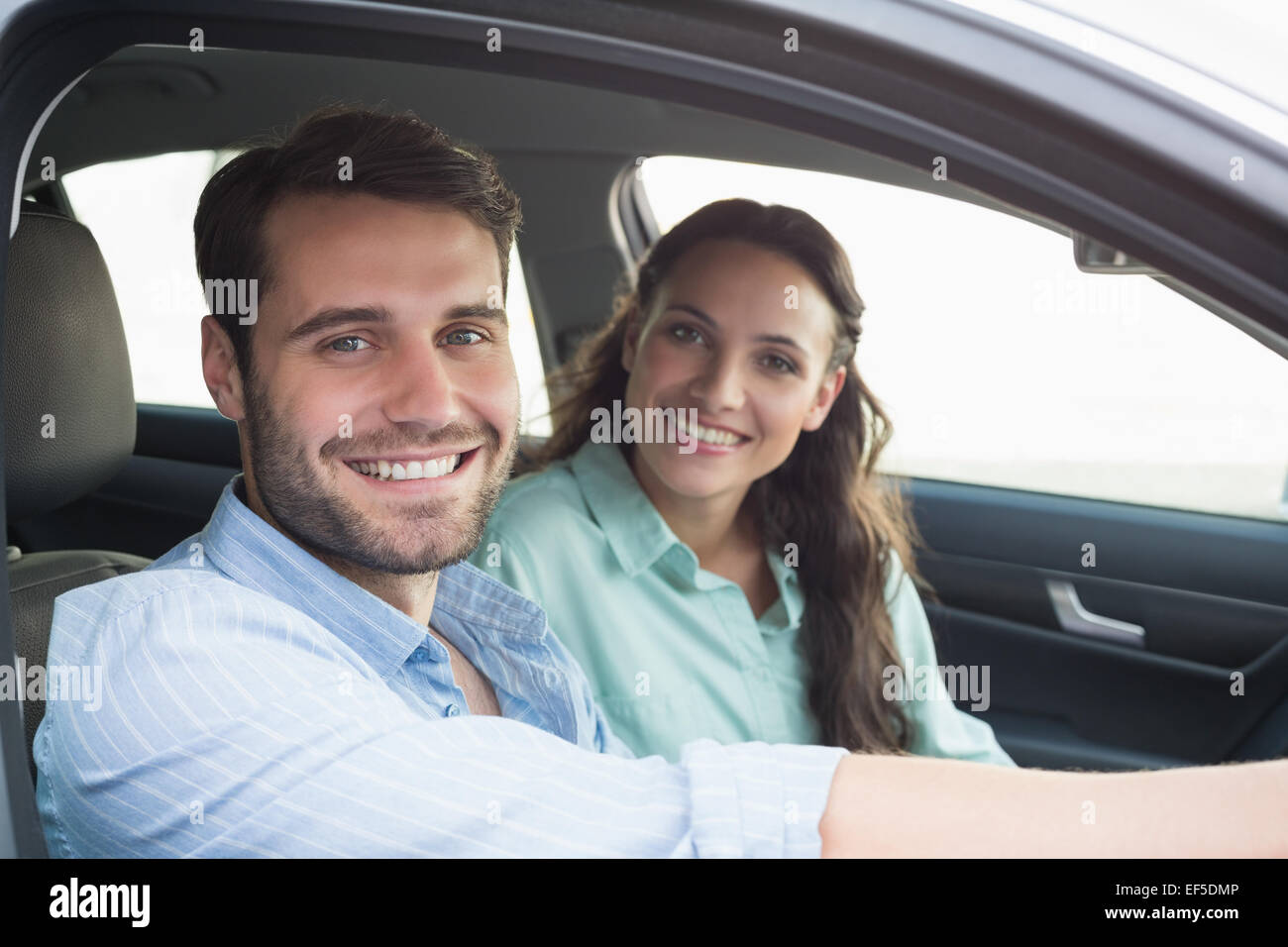 Young couple smiling at the camera Stock Photo - Alamy