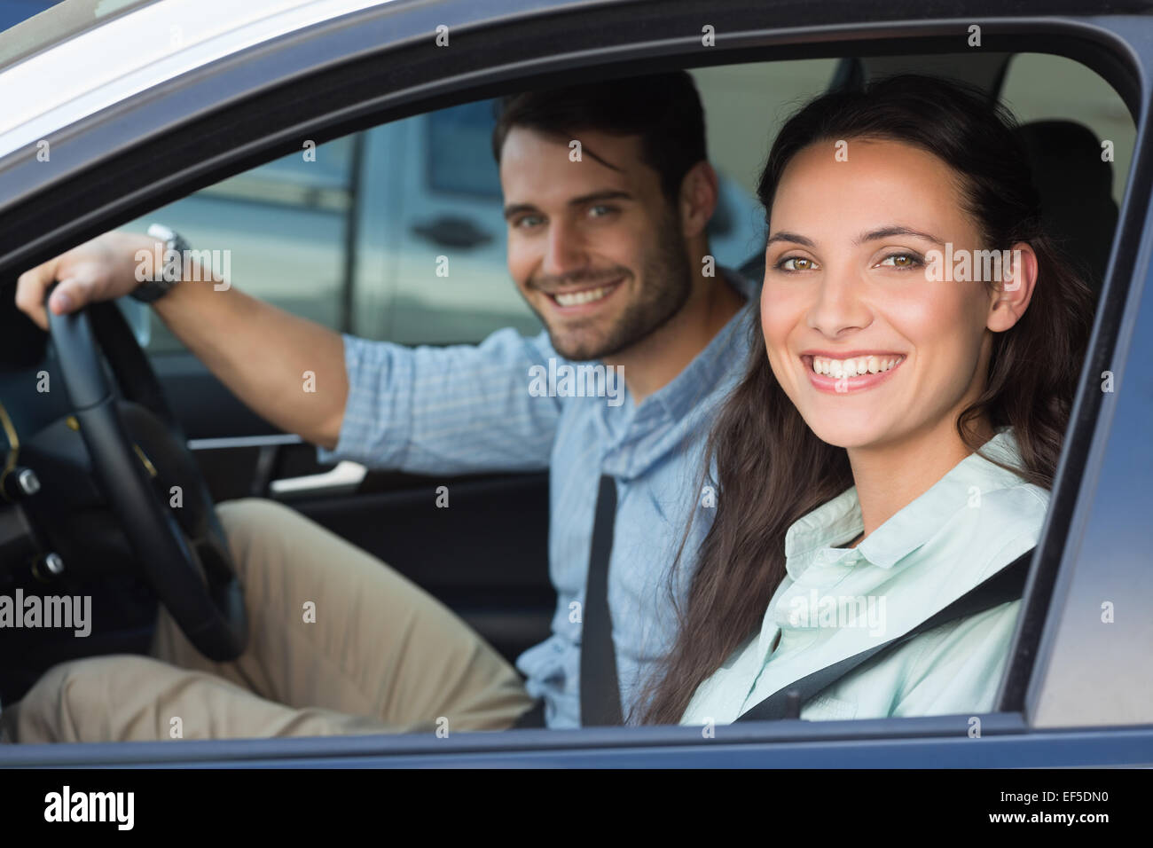 Young couple smiling at the camera Stock Photo - Alamy
