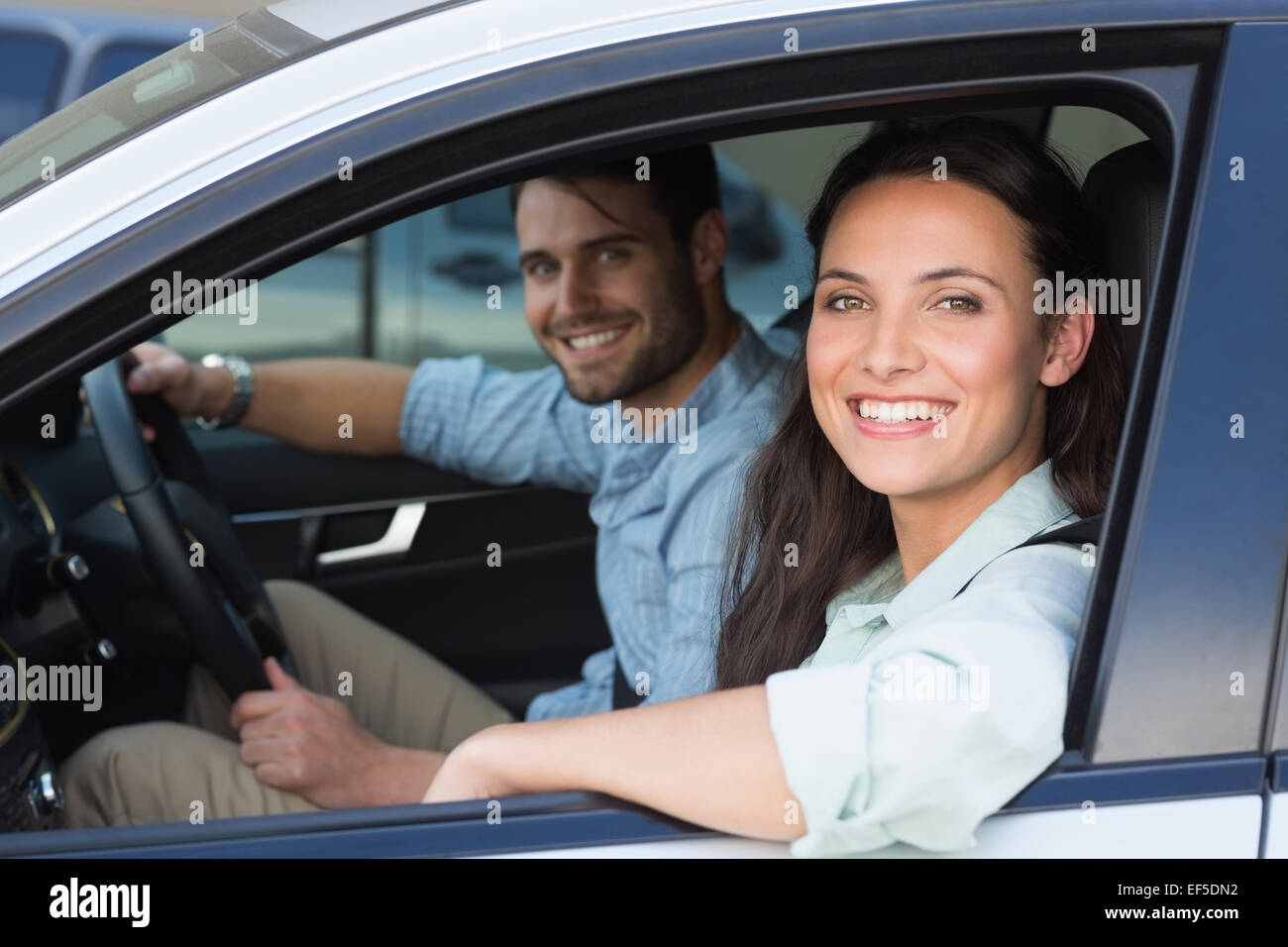 Young couple smiling at the camera Stock Photo - Alamy