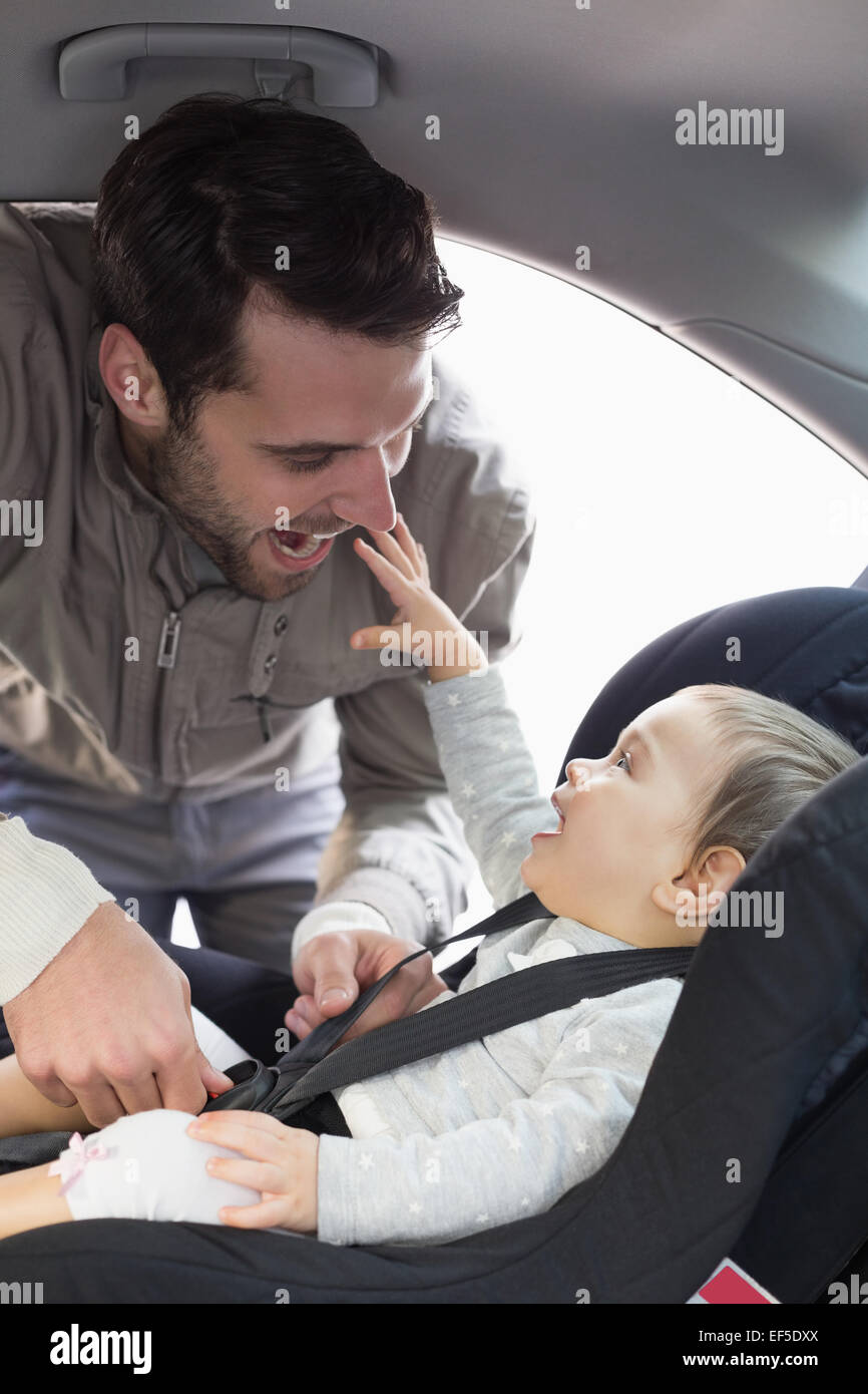 Father securing baby in the car seat Stock Photo