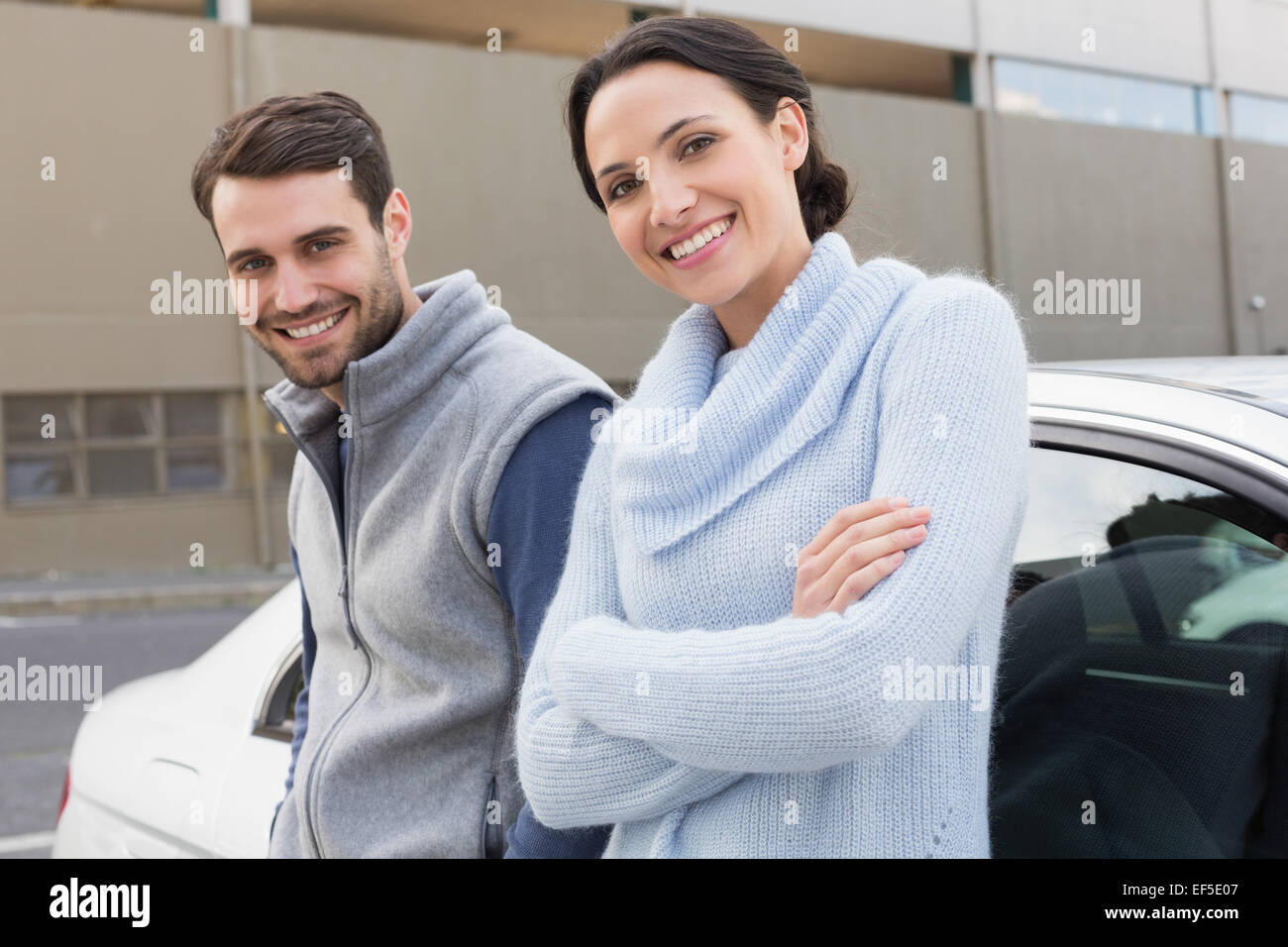 Young couple smiling at the camera Stock Photo - Alamy