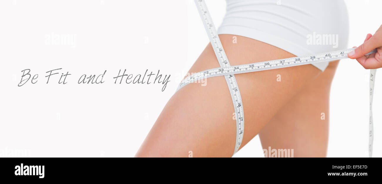 Midsection of woman measuring thigh Stock Photo