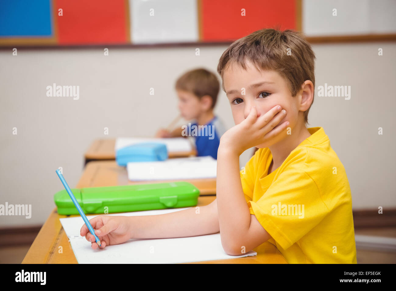 Thoughtful pupil sitting at his desk Stock Photo - Alamy