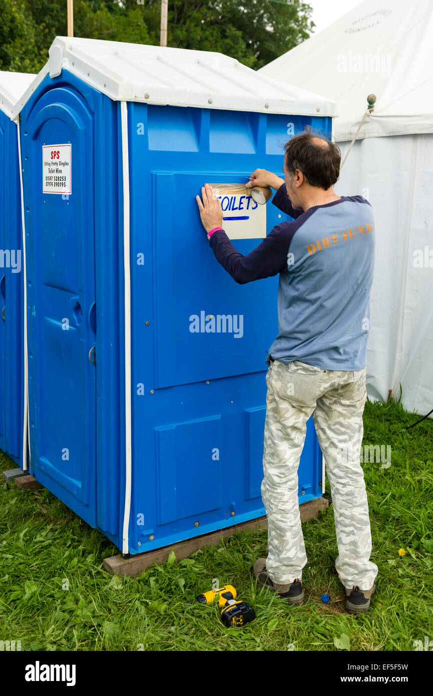 Sheep Music festival, Presteigne, Powys, UK. Putting up signs on the festival toilets Stock Photo