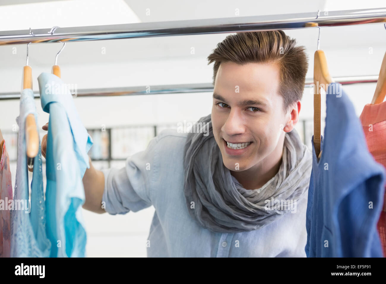 Smiling student near clothes rack Stock Photo Alamy