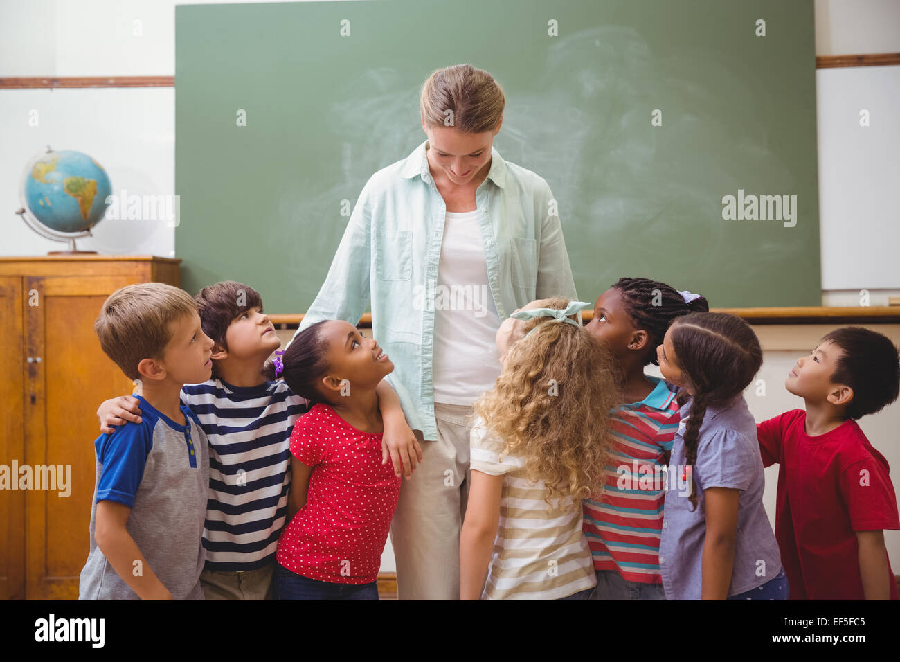 Cute pupils smiling at camera in classroom Stock Photo - Alamy