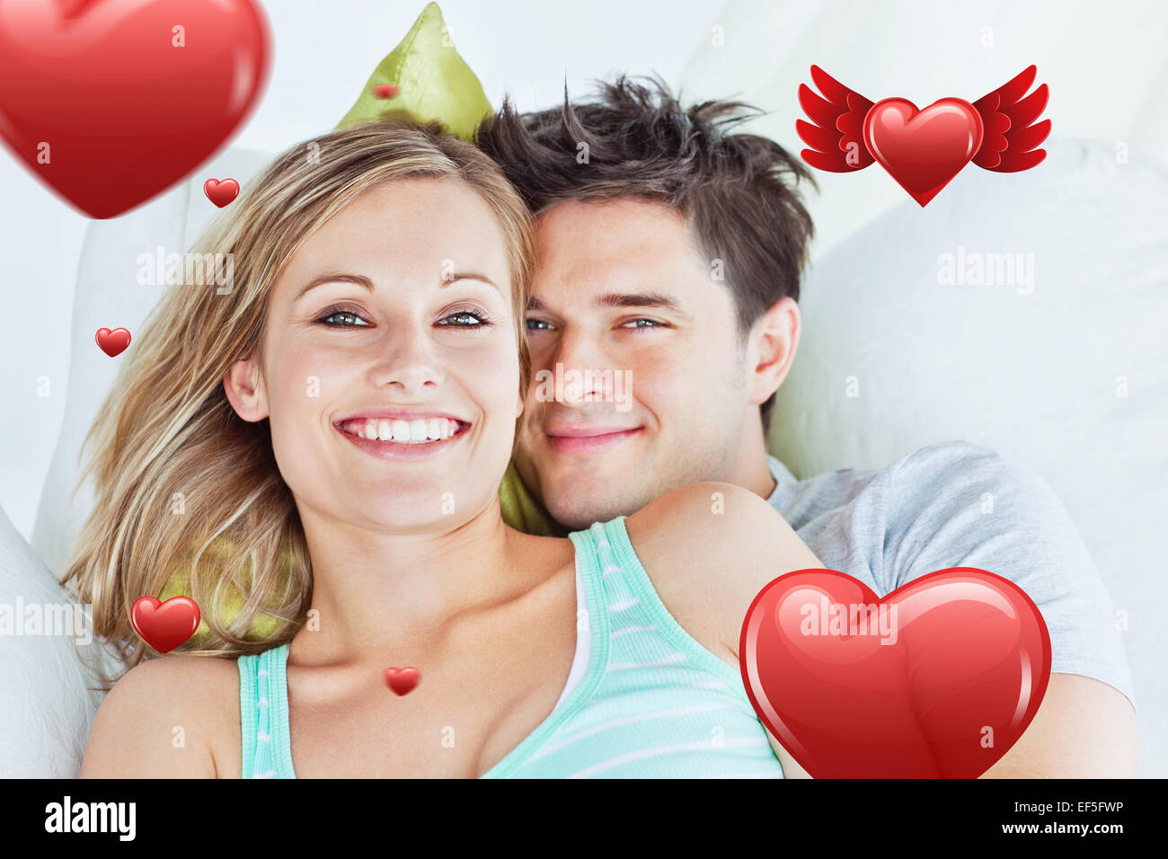 Composite image of portrait of an attractive couple hugging and relaxing on the sofa Stock Photo