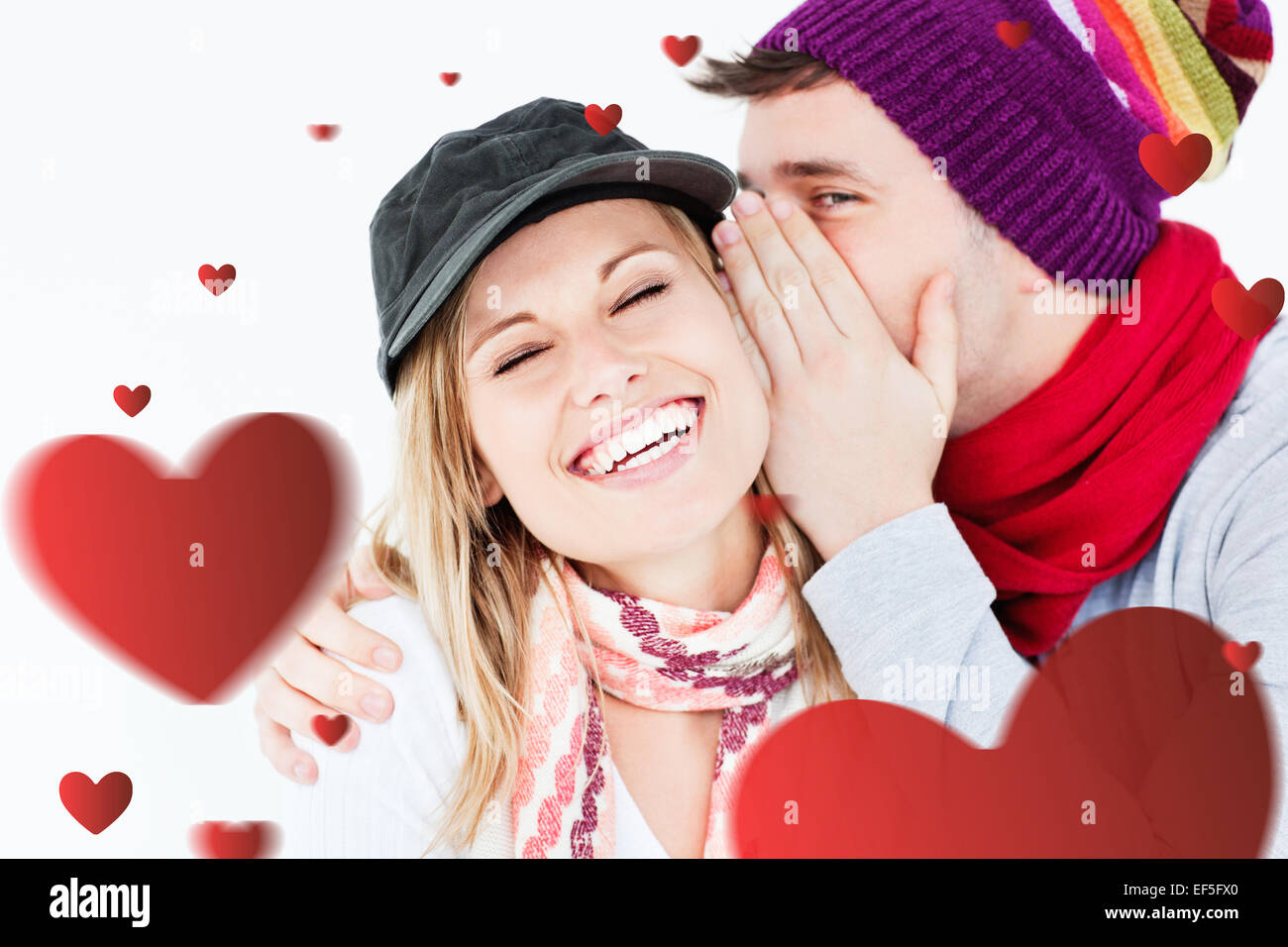 Composite image of young couple sharing a secret Stock Photo