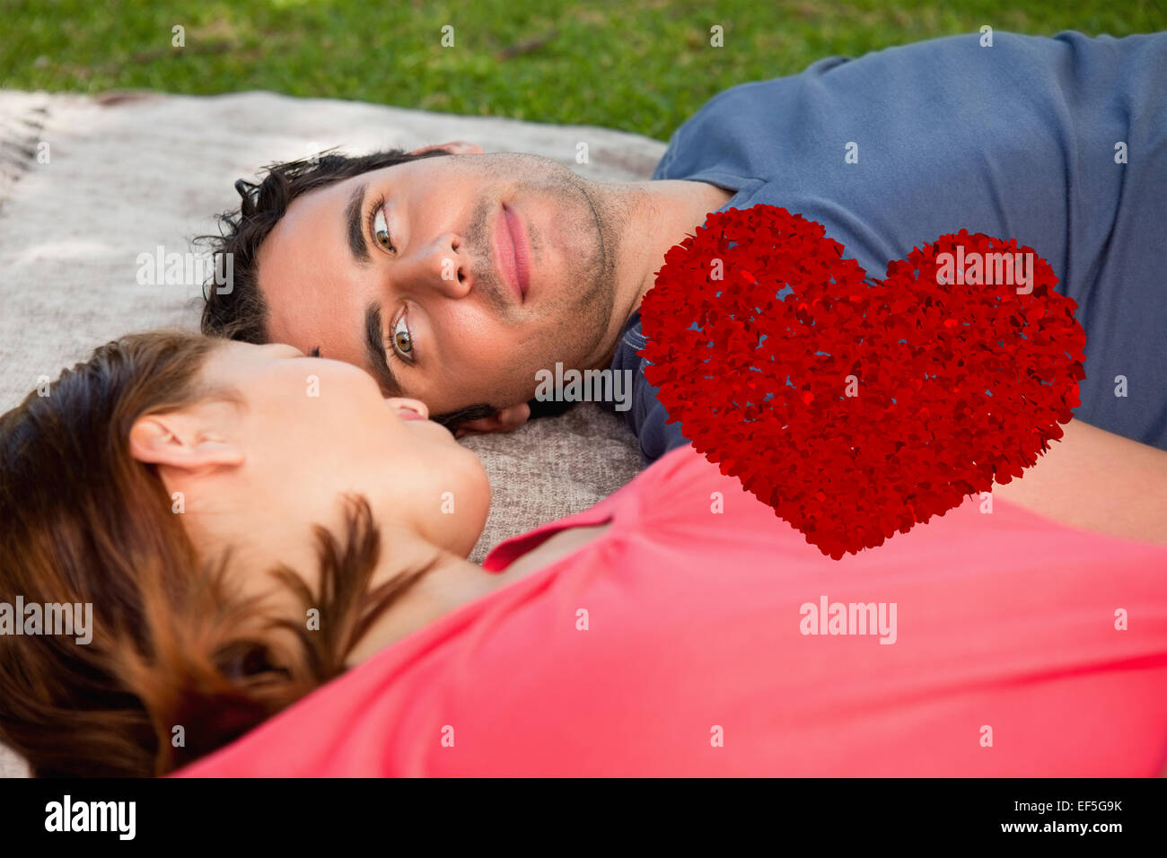 Composite image of man looking into his friends eyes while lying on a quilt Stock Photo