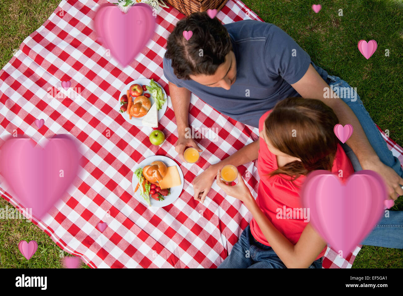 Composite image of elevated view of two friends lying on a blanket with a picnic Stock Photo