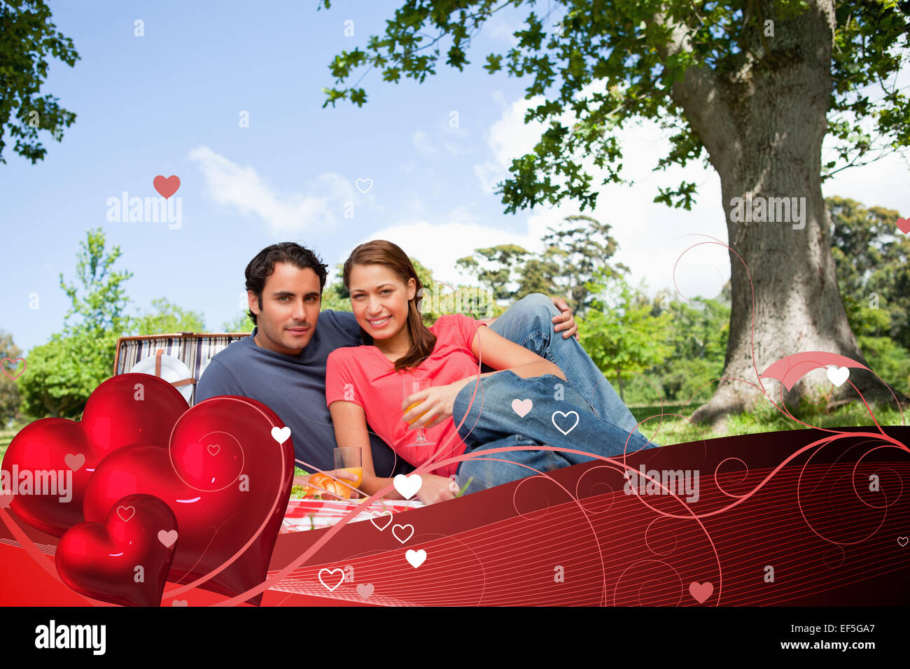 Composite image of two friends looking ahead while they hold glasses as they have a picnic Stock Photo