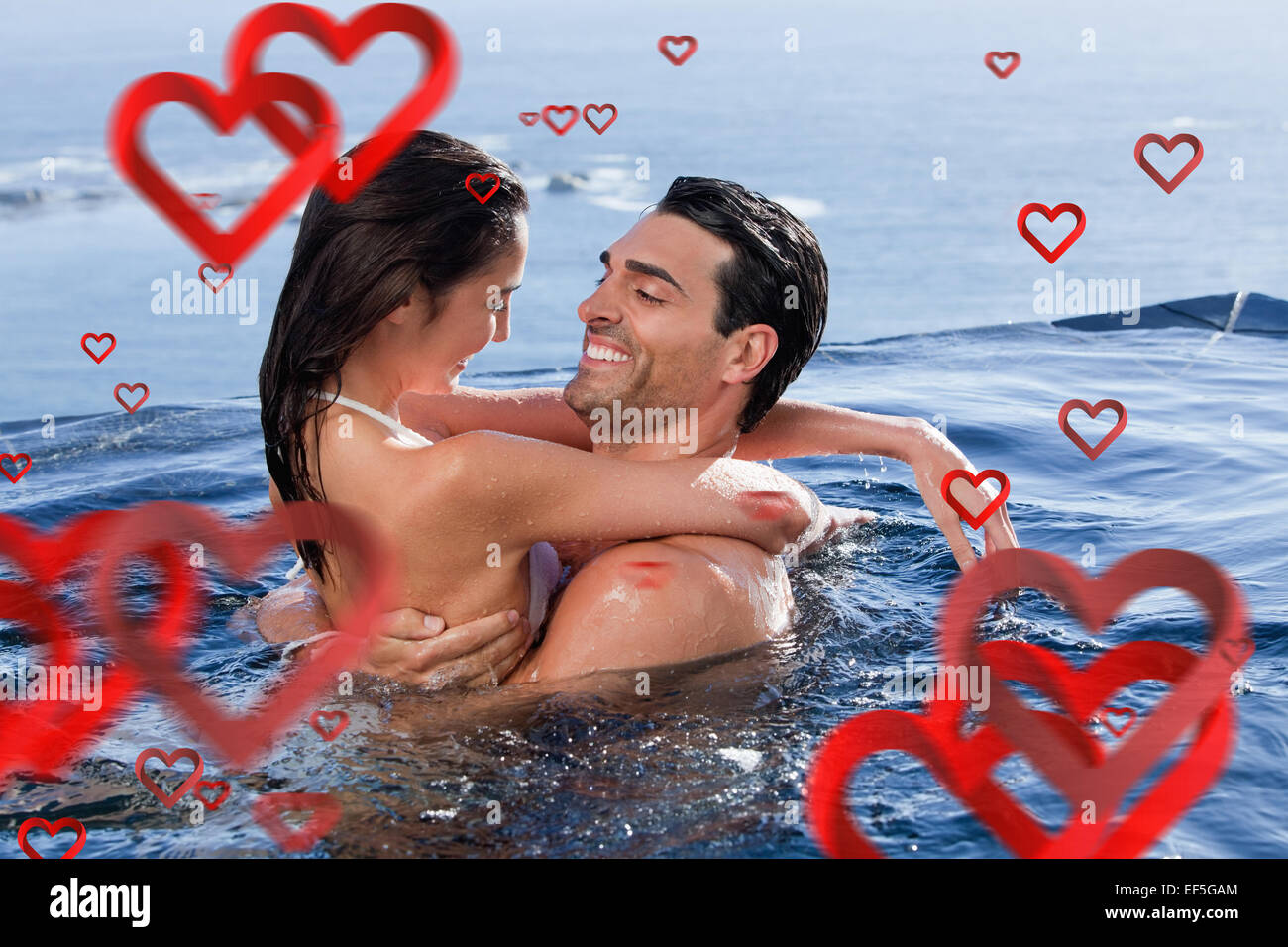 Composite image of delighted couple cuddling each other Stock Photo