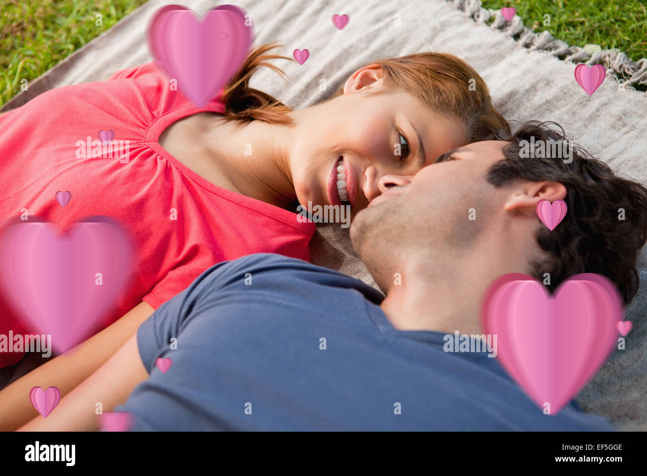 Composite image of woman looking into her friends eyes while lying on a quilt Stock Photo