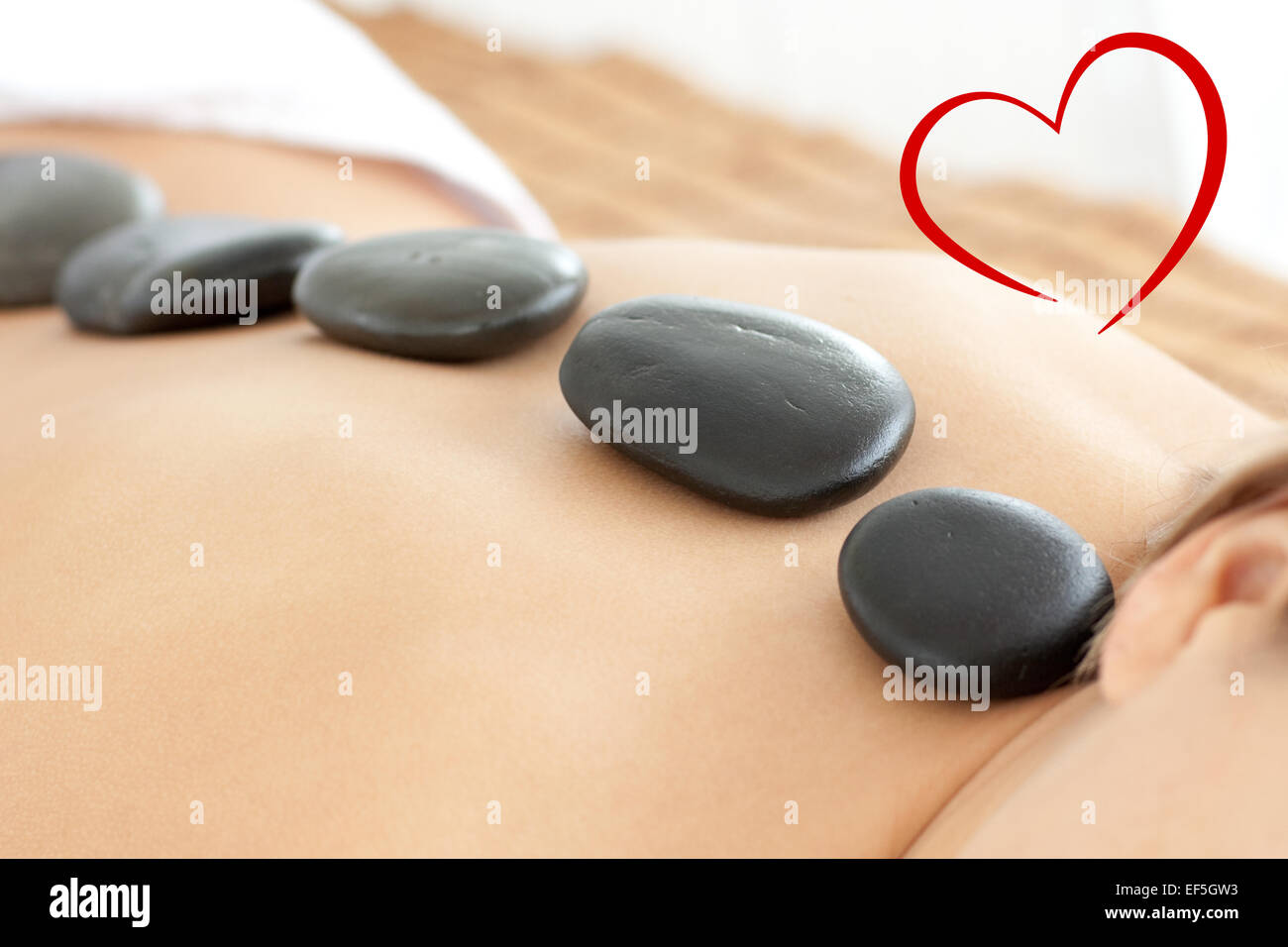 Composite image of close up of a woman with hot stones on her back Stock Photo