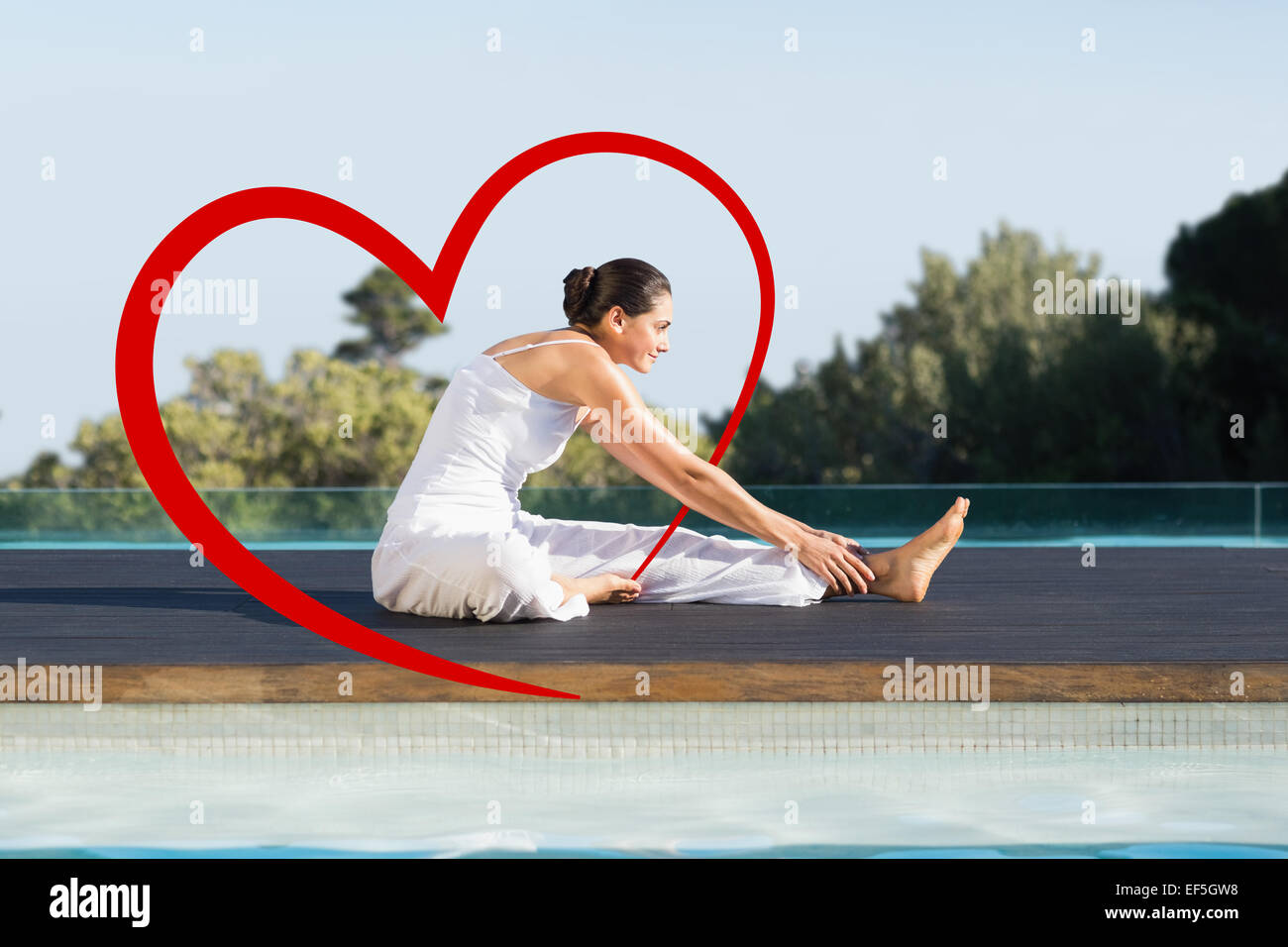 Composite image of peaceful brunette in janu sirsasana yoga pose poolside Stock Photo