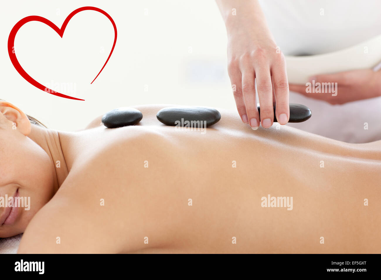 Composite image of portrait of a beautiful woman having a massage with stones Stock Photo