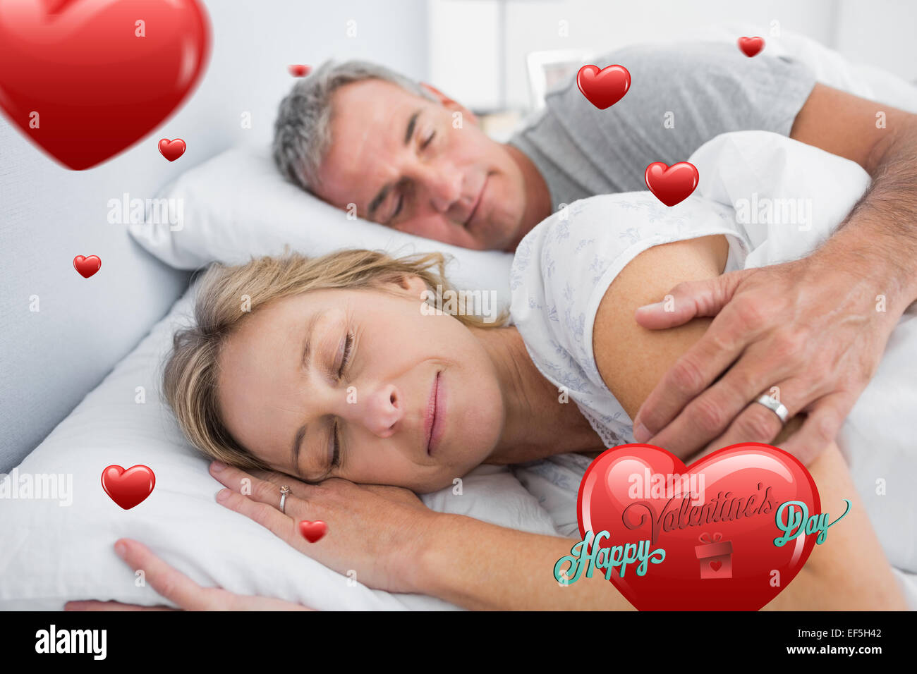 Composite image of couple sleeping and spooning in bed Stock Photo