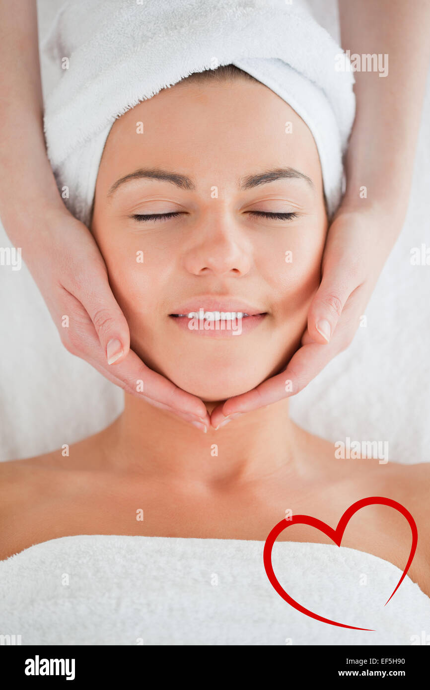 Composite image of portrait of a smiling woman having a facial massage Stock Photo