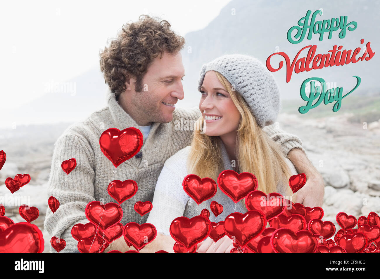 Composite image of happy couple sitting together on rocky landscape Stock Photo