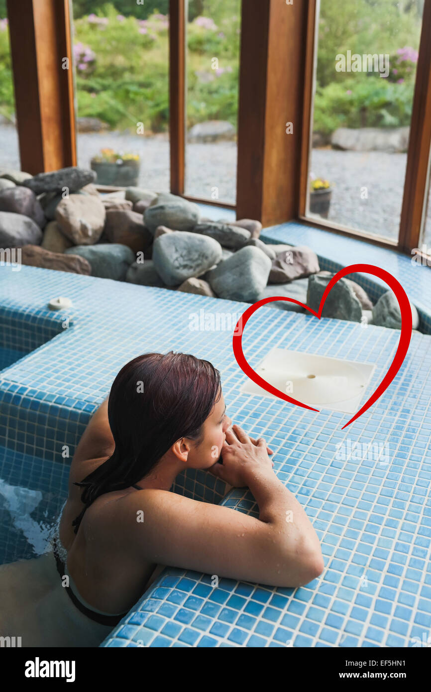 Composite image of brunette relaxing in a jacuzzi Stock Photo