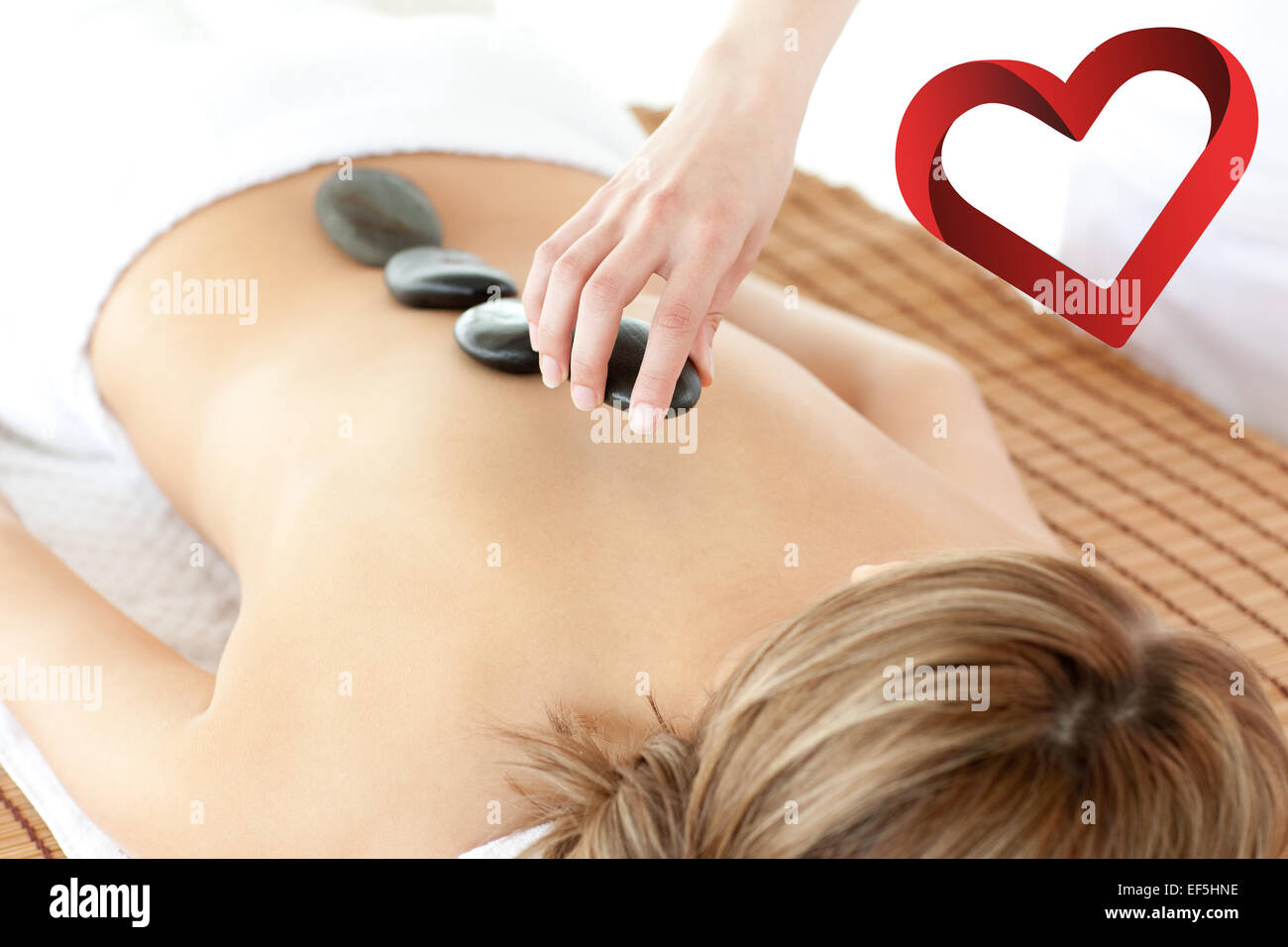 Composite image of radiant woman having a stone therapy Stock Photo