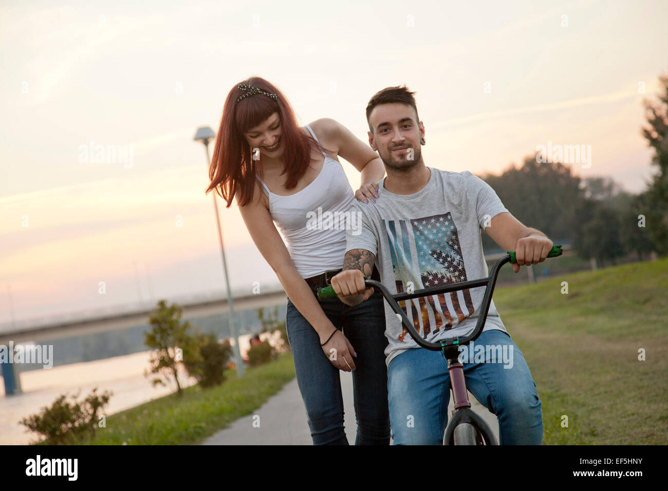 Young couple with BMX bicycle outdoors Stock Photo