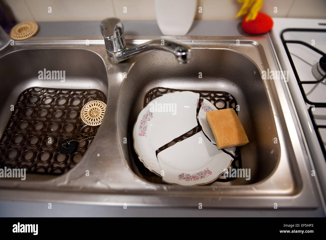 Broken plate and dish sponge on plastic mat in sink Stock Photo Alamy