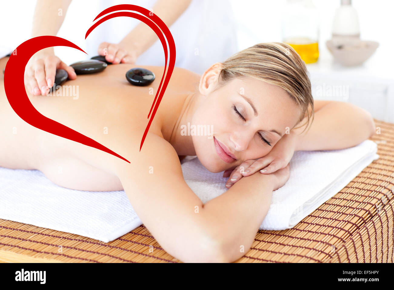 Composite image of pretty young woman receiving a massage with hot stone Stock Photo