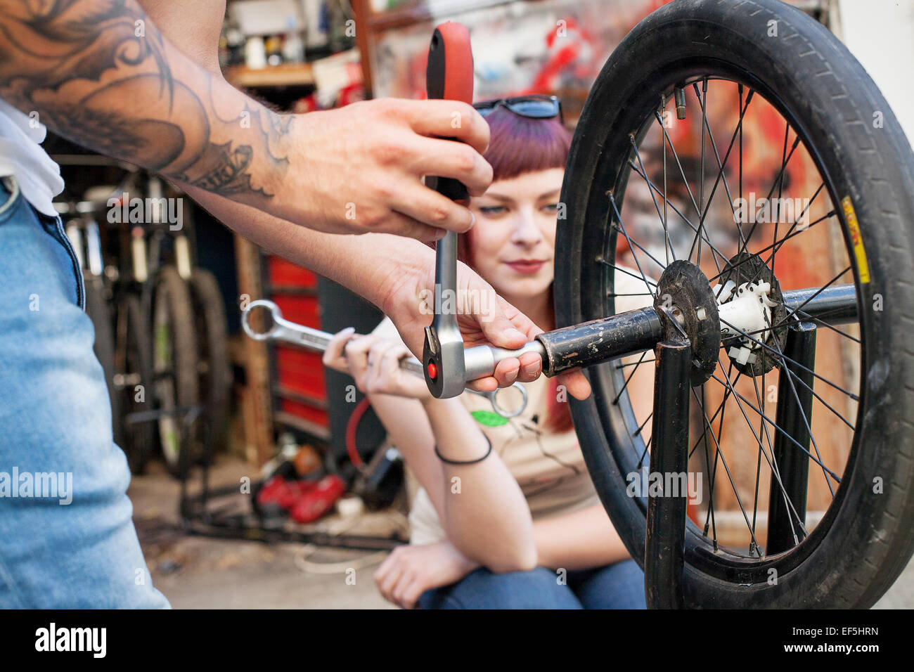 Young couple in workshop repairing BMW bicycle Stock Photo - Alamy